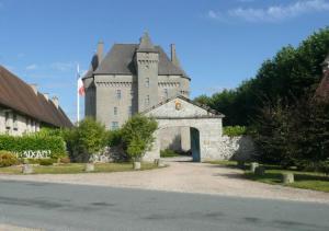 un vieux château avec une porte au milieu d'une route dans l'établissement Château De Saint-Maixant, à Saint-Maixant