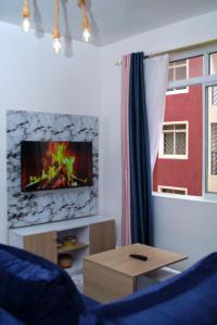 a living room with a tv on a wall at EDENVILLE HOMES-1 Bedroom Apartment Kiambu Road, Thindigua in Nairobi