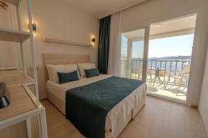 a bedroom with a large bed with a balcony at Mia Hill Suites in Bodrum City