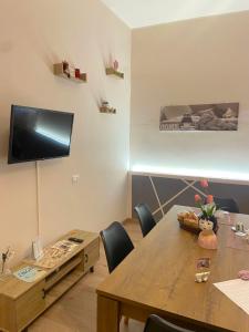 a dining room with a table and chairs and a television at Aria di Casa in Calatafimi