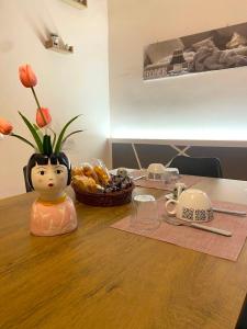 a table with a vase with flowers on top of it at Aria di Casa in Calatafimi