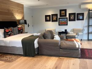 a bedroom with a bed and a couch at The Whale's Tale Guesthouse in Hermanus
