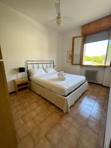 Un dormitorio con una cama grande y una ventana. en Vittorio Veneto, en Milano Marittima
