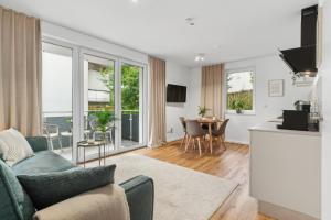 a living room with a couch and a kitchen and a table at Stylisches Apartment mit Balkon & kostenlosem Parkplatz Beste Lage in Bielefeld in Bielefeld
