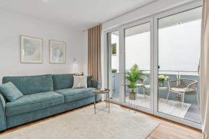 a living room with a blue couch and a balcony at Stylisches Apartment mit Balkon & kostenlosem Parkplatz Beste Lage in Bielefeld in Bielefeld