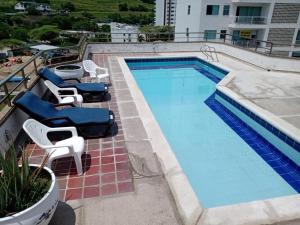 a swimming pool with two chairs and a table at El Rodadero, 4 habitaciones con piscina y terraza in Gaira