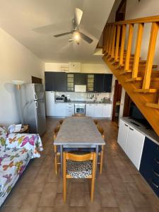 Una cocina y un comedor con una mesa y una cama. en Vittorio Veneto, en Milano Marittima