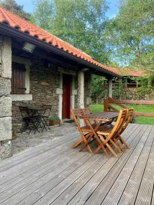 eine Holzterrasse mit einem Tisch und 2 Stühlen in der Unterkunft Casa da Branda St.António in Branda de Santo António