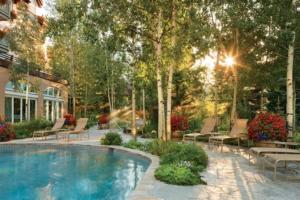 a swimming pool in a yard with benches and a house at Vail Sonnenalp King Hotel Room in Vail