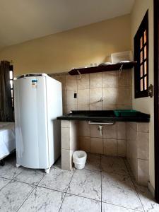 a kitchen with a white refrigerator in a room at Pousada Morada Dusanjos in Caraguatatuba