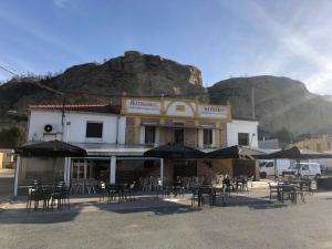 a building with chairs and umbrellas in front of it at Hernani Bardenas in Arguedas