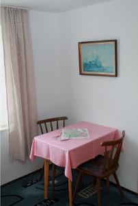 a table with a pink table cloth on it with two chairs at Haus Rita in Thurmansbang
