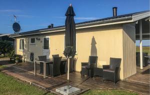 a patio with an umbrella and chairs and a table at Nice Home In Rudkøbing With Wifi in Spodsbjerg +22 photos