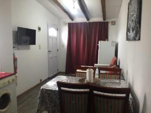 a dining room with a table and chairs and a refrigerator at Donde la Zulema in Malargüe