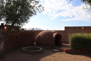 a brick wall with a brick oven in a yard at Estancia Los Amigos Valle de Guadalupe in Valle de Guadalupe
