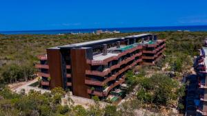 an aerial view of a building with the ocean in the background at Seascape apartment near the beach with a sea-view rooftop and infinity pool in Tulum