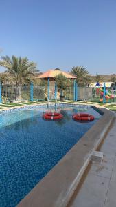 a pool with a water slide in a playground at Mountain village house in Ḑab‘ah