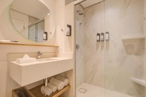 a bathroom with a sink and a shower at Hampton by Hilton Guarulhos Airport in Guarulhos +37 photos