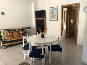 een eetkamer met een witte tafel en stoelen bij Casa Marylu con giardino in Marina di Schiavonea