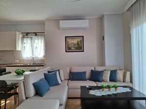 a living room with a couch and a table at Aurora - Close to Macedonia Airport in Kardiá