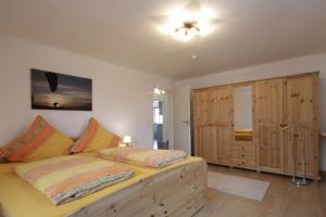 1 dormitorio con 1 cama y armarios de madera en Haus Ingrid, en Trauchgau