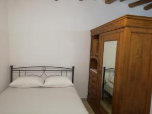 a bedroom with a bed and a dresser and a mirror at Aloni Farmhouse in Karistos