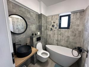a bathroom with a white tub and a toilet at Apartament Anne Marie - Ibo Residence in Mamaia Nord +4 photos