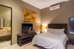a bedroom with a large bed and a television at Villa Alegria in El Pueblito