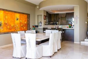 a dining room with a table and white chairs at Villa Alegria in El Pueblito