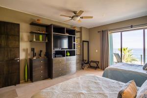 a bedroom with a bed and a dresser with a television at Villa Alegria in El Pueblito