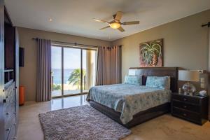 a bedroom with a bed with a ceiling fan and a window at Villa Alegria in El Pueblito +37 photos