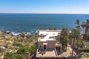 a house on a hill next to the ocean at Villa Alegria in El Pueblito