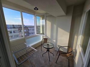 a room with two chairs and a table and two windows at Cip Apartament Tazlaului in Bacău
