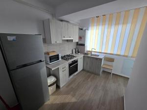 a kitchen with a refrigerator and a stove at Cip Apartament Tazlaului in Bacău