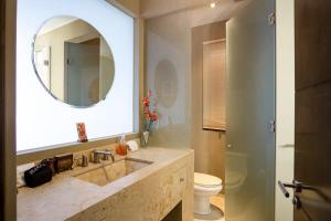 a bathroom with a sink and a toilet and a mirror at Villa Alegria in El Pueblito