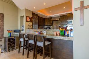 a kitchen with a bar with bar stools at Villa Alegria in El Pueblito