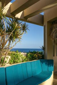 a blue couch on a balcony with a view of the ocean at Villa Alegria in El Pueblito