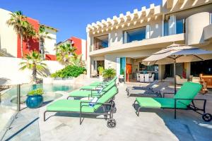 a row of chaise lounge chairs next to a swimming pool at Villa Alegria in El Pueblito