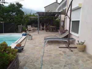 a backyard with a swimming pool and a patio at Chambre d'hôte Partine Cap Corse in Santa-Maria-di-Lota +1 photo