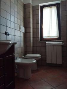 a bathroom with a toilet and a sink and a window at Appartamento Mainarde in Capracotta