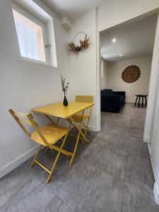 a dining room with a yellow table and chairs at Longsap, paisible appartement in Seysses