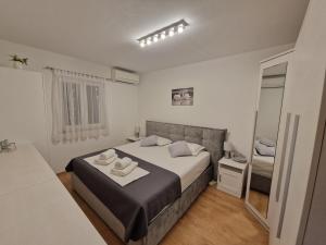 a bedroom with a large bed and a mirror at Apartment CHARLY in Supetar