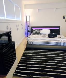 a bedroom with two beds and a black and white rug at Comfy Stylish Room in the Heart of Vancouver- Private Parking, Self Check-in & just 4 mins to Metrotown! in Vancouver