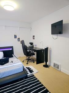 a bedroom with a bed and a desk with a computer at Comfy Stylish Room in the Heart of Vancouver- Private Parking, Self Check-in & just 4 mins to Metrotown! in Vancouver