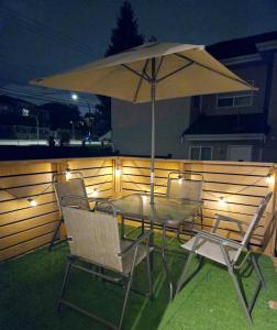 a table and chairs with an umbrella on a patio at Comfy Stylish Room in the Heart of Vancouver- Private Parking, Self Check-in & just 4 mins to Metrotown! in Vancouver