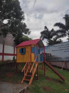 a small playground with a slide and a house at Chácara Harmonia Pouso Alegre in Pouso Alegre +4 photos