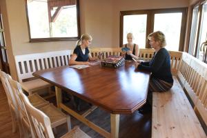 three women sitting at a table in a room at aQuarium Panzió in Abádszalók +59 photos