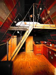 a kitchen with a staircase in the middle of a room at Sparrow Cabin Hot Tub in Barham