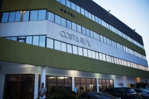 a building with a man standing outside of it at Hotel Costa Real in Maracaibo