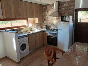a kitchen with a white refrigerator and a table at Casa do Marinheiro in Sesimbra